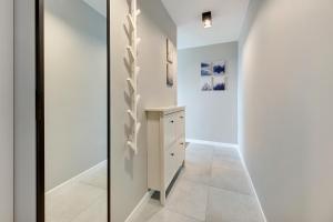 korytarz z białymi ścianami, szafką i ścianą w obiekcie Comfort Apartments Wyspiańskiego w mieście Gdynia