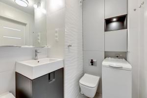biała łazienka z umywalką i toaletą w obiekcie Comfort Apartments Wyspiańskiego w mieście Gdynia +10 zdjęć