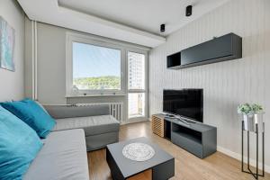 salon z kanapą i telewizorem w obiekcie Comfort Apartments Wyspiańskiego w mieście Gdynia