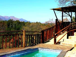 a wooden deck with a swimming pool next to a wooden stairs at Thula Du Estate - family houses in Mbabane