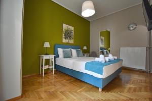 a bedroom with a large bed with green walls at Check Point - Koukaki in Athens