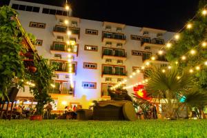- un grand bâtiment blanc avec des lumières devant dans l'établissement Hotel Palacio Maya, à Mérida