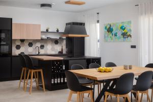 a kitchen with a wooden table and chairs and a table and a counter at Villa 9 in Podstrana