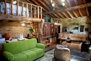 a living room with a green couch and a table at Aldeia da Mata Pequena in Mafra