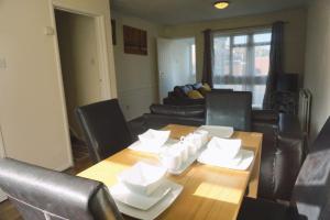 a living room with a wooden table and leather chairs at The Harvest 2 in Canterbury