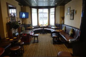 een wachtkamer met leren banken en tafels en stoelen bij The Kings Cross Hotel in Blackpool