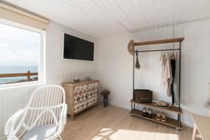 vestidor con silla blanca y ventana en La Cabaña de la playa, en Ajo