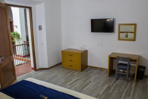 Habitación con cama, escritorio y TV. en Hotel Real de Castilla Colonial, en Guadalajara