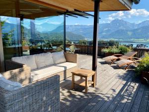 eine Terrasse mit einem Sofa und Tischen auf einer Terrasse in der Unterkunft The View in St. Wolfgang