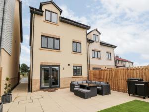 une maison avec une terrasse et une clôture dans l'établissement Amble Views, à Morpeth
