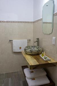 a bathroom with a sink and a mirror and towels at Hotel Real de Castilla Colonial in Guadalajara