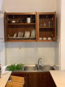 a kitchen with wooden cabinets and a sink at Kassavetis Center - Hotel Studios & Apartments in Hersonissos