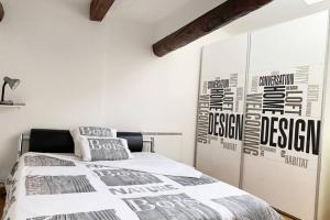 a bedroom with a bed and a wall with posters at Calme dans Maison de village 60M2 super confort in Digne-les-Bains
