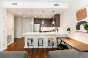 a kitchen with a counter and stools in a room at Kislak 603 1BR Penthouse with Stunning Rooftop Terrace in Newark