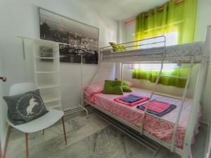 a small bedroom with a bunk bed and a chair at Apartamento y Parking en pleno CENTRO, DAMAS in Huelva