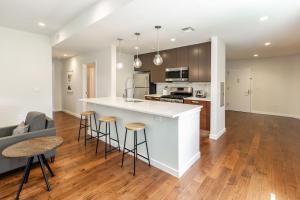 a kitchen and living room with a counter and stools at Kislak 303 Luxurious 2BR in Heart of Downtown in Newark