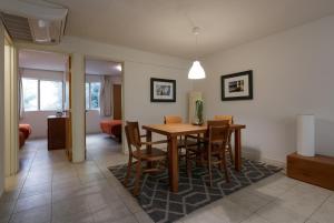 Apartamentos West End في غواذالاخارا: غرفة طعام وغرفة معيشة مع طاولة وكراسي