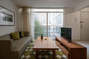 - un salon avec un canapé et une télévision dans l'établissement Apartamentos West End, à Guadalajara