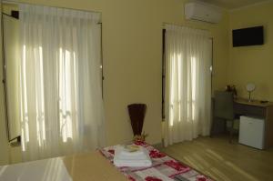 een slaapkamer met een bed met witte gordijnen en een bureau bij Da zia Rosina in Lamezia Terme