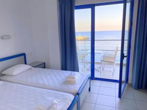 a bedroom with a bed and a view of the ocean at Kassavetis Center - Hotel Studios & Apartments in Hersonissos +169 photos