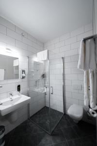 a bathroom with a sink, toilet and shower stall at Lakeside77 in Podersdorf am See