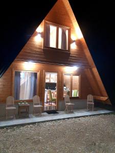 a house with chairs and a table and windows at Holiday Home Ella - Apartman Ella in Mokra Gora