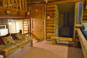 a living room with a couch in a log cabin at Cabaña Suiza in Cacheuta