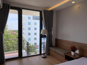 a hotel room with a bed and a large window at Rang Dong Hue Hotel in Hue