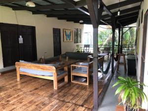 a room with a table and a bench on a wooden floor at Be My Guest Cabinas in Puerto Viejo