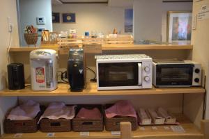 a kitchen with two microwaves on a shelf at Hana Hostel Fujisan in Fujiyoshida