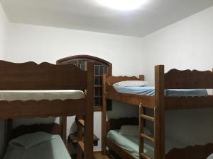 a room with three bunk beds in a room at Sítio dos Rodrigues in Lindóia