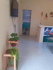 a living room with two tables and a tv at Pousada Beira Rio in Santo Amaro
