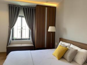 a bedroom with a large bed with a window at Rang Dong Hue Hotel in Hue