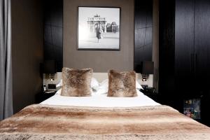 1 dormitorio con 1 cama grande con sábanas y almohadas blancas en Hôtel Elysées Paris, en París