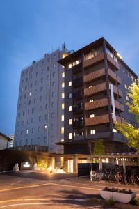 a large building with bikes parked in front of it at Central Hotel Takeoonsen Ekimae in Takeo