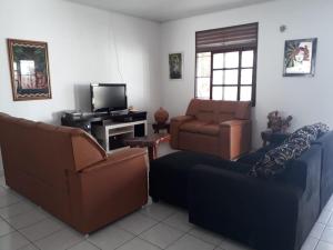 a living room with two couches and a tv at Casa Amarela in Paripueira