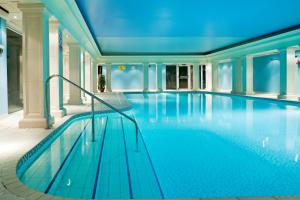 a large swimming pool in a building with blue lighting at Hythe Imperial Hotel, Spa & Golf in Hythe
