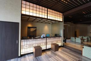 een lobby met een receptie en 2 stoelen bij Hotel Kanade Kanku Kaizuka in Kaizuka