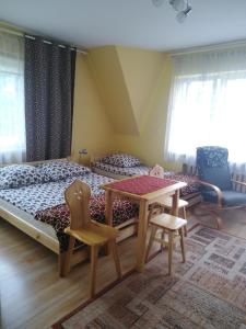 Schlafzimmer mit einem Bett, einem Tisch und Stühlen in der Unterkunft Trybałowa Ostoja in Zawoja