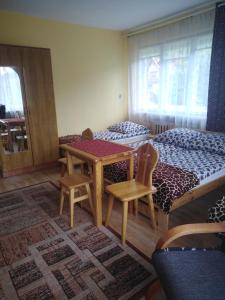 a bedroom with a bed and a table and chairs at Trybałowa Ostoja in Zawoja