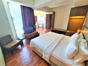 a bedroom with a bed and a chair and a desk at Nexus Regency Suites & Hotel in Subang Jaya