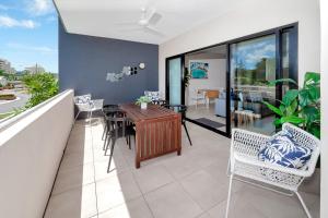 a dining room with a table and chairs on a balcony at Apartment Close to the City Life on Lake 3 in Cairns North