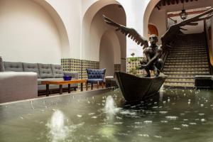 Una estatua de una chica en un barco en el agua en Hotel Real de Castilla Colonial en Guadalajara