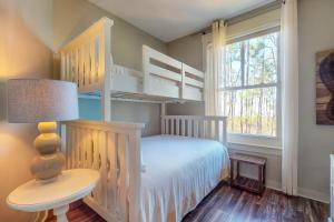 a bedroom with bunk beds and a table and a lamp at Bahia Condos in Destin
