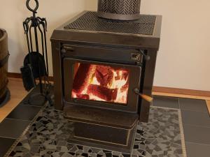 a stove with a fire inside of it at The Cosy Cottage in Port Sorell