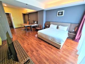 a bedroom with a bed and a desk and a table at Nexus Regency Suites & Hotel in Subang Jaya