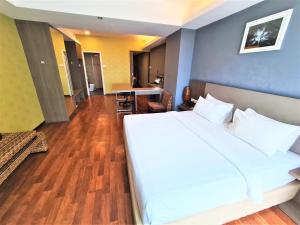 a bedroom with a large white bed and a table at Nexus Regency Suites & Hotel in Subang Jaya