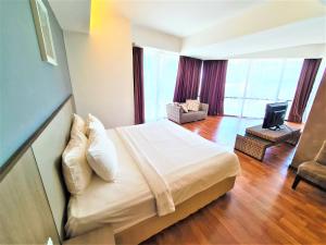 a bedroom with a bed and a living room at Nexus Business Suite Hotel in Shah Alam