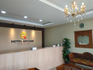 a hotel reception lobby with a sign on the wall at Qeyjan Hotel in Pasir Puteh