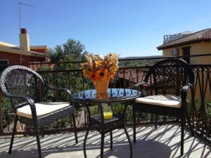 un tavolo da patio con due sedie e un vaso di fiori di Carpe Diem a Olbia